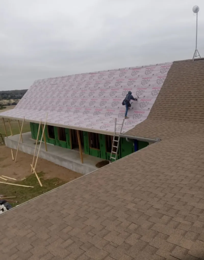 Worker preparing underlayment for a metal roof installation in Upper Gwynedd